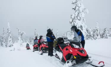 Motoneiges et leurs conducteurs dans un paysage blanc neige.