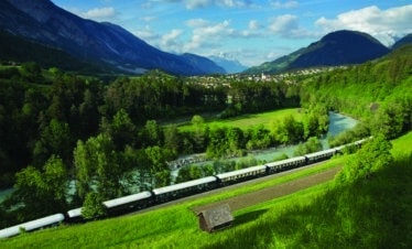 Le train mythique the Venice Simplon Orient Express dans un magnifique paysage verdoyant