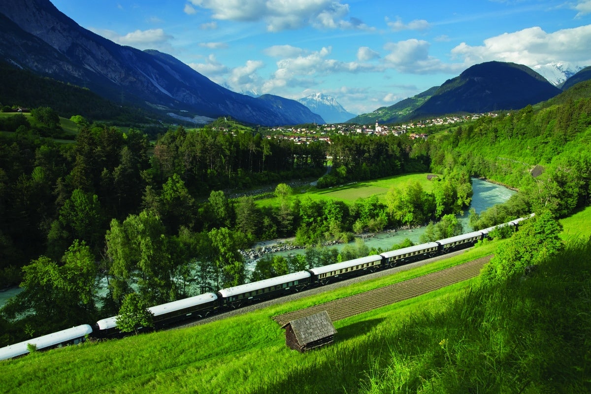 Le train mythique the Venice Simplon Orient Express dans un magnifique paysage verdoyant