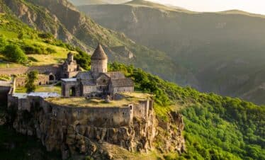 Majestueux château en pierres perché sur sa colline avec vue sur les montagnes