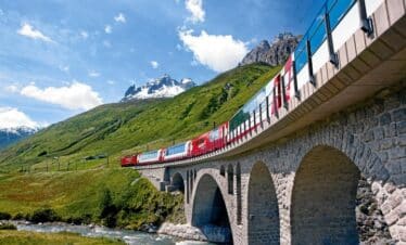 Train traversant un pont dans un paysage verdoyant typique de la Suisse