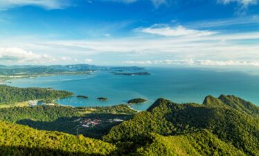 mer turquoise encadrée par une végétation verdoyante, vue sur un relief impressionnant